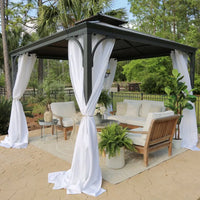 Outdoor patio with a metal gazebo, furniture, and plants on a stone patio.