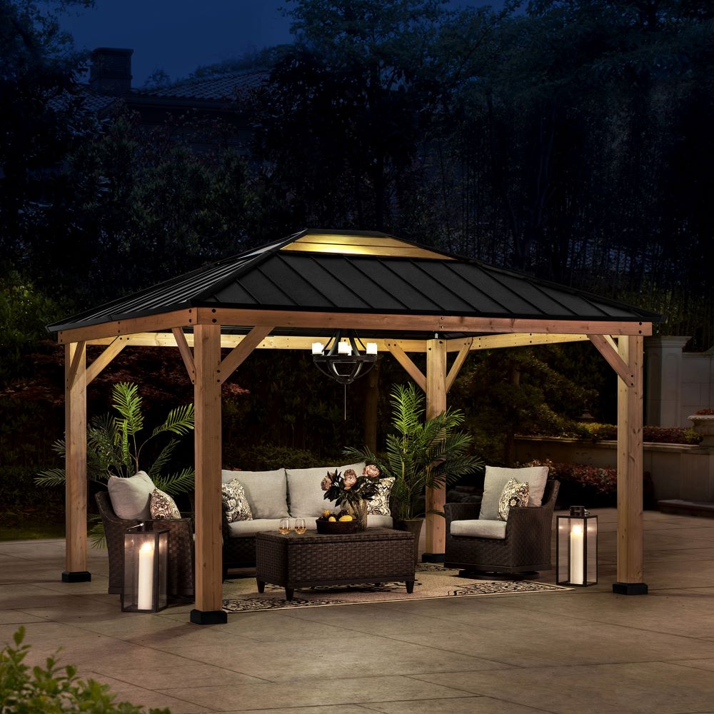 Wooden gazebo with outdoor furniture and lighting in a backyard setting