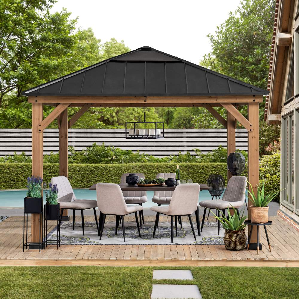 Wooden gazebo with outdoor furniture and decor in a backyard setting.