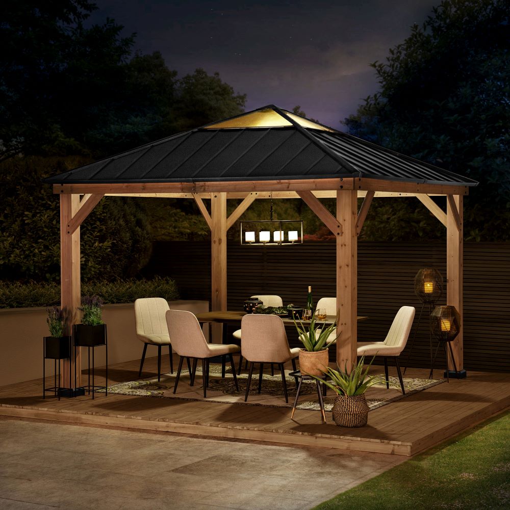 Wooden gazebo with outdoor furniture and lighting at night
