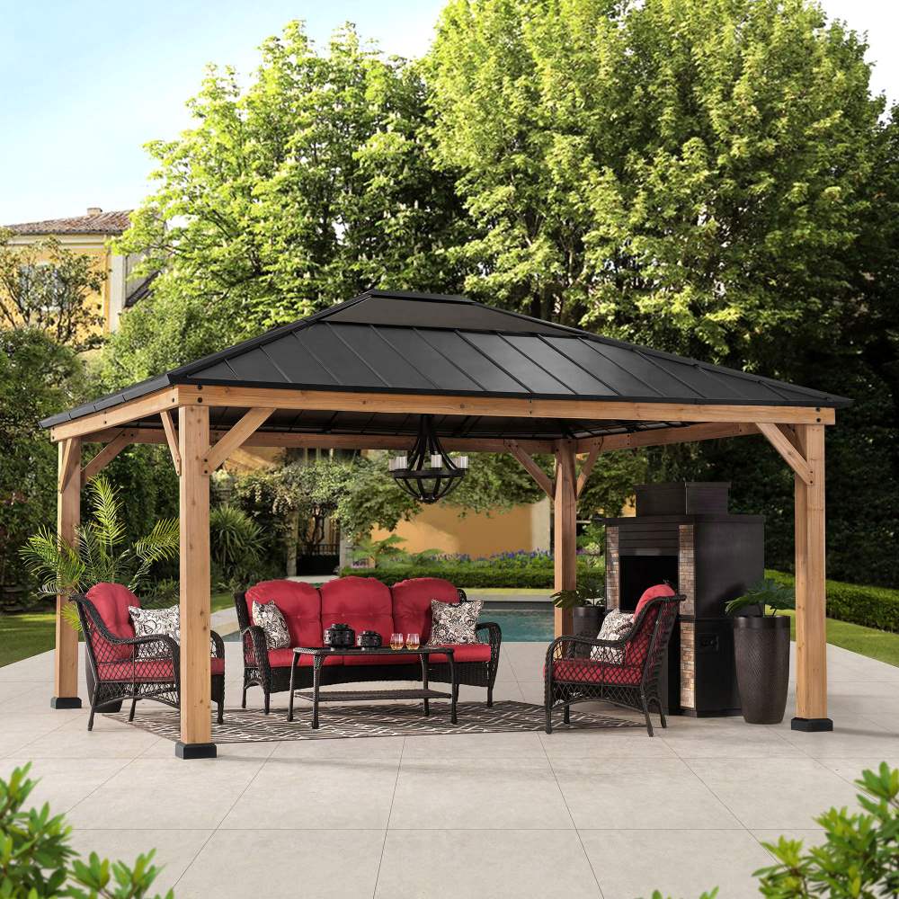 Wooden gazebo with red outdoor furniture set in a garden setting.