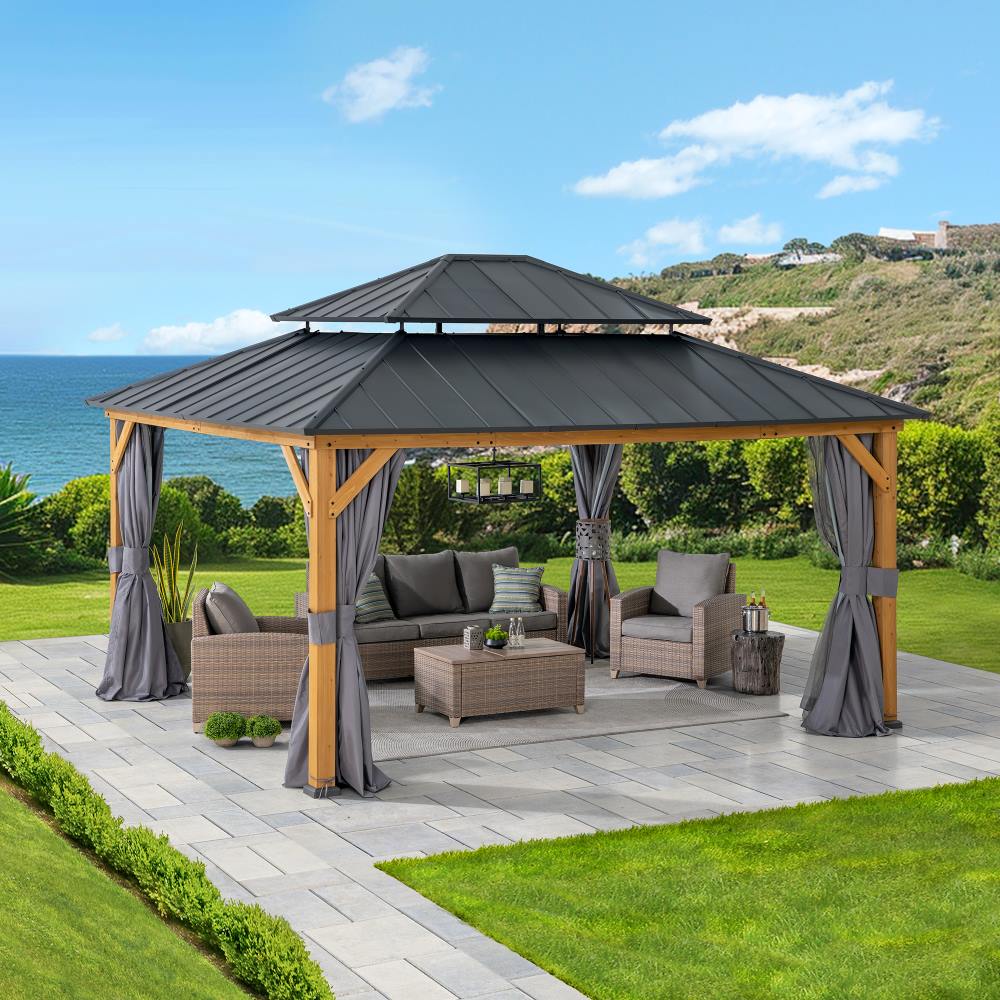 Outdoor gazebo with patio furniture and curtains on a patio overlooking a scenic view.