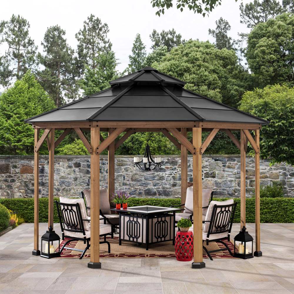 Wooden gazebo with a black roof on a patio area with outdoor furniture and decor.