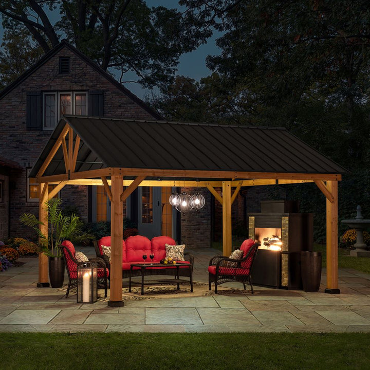 Wooden pergola with outdoor furniture and lighting at night