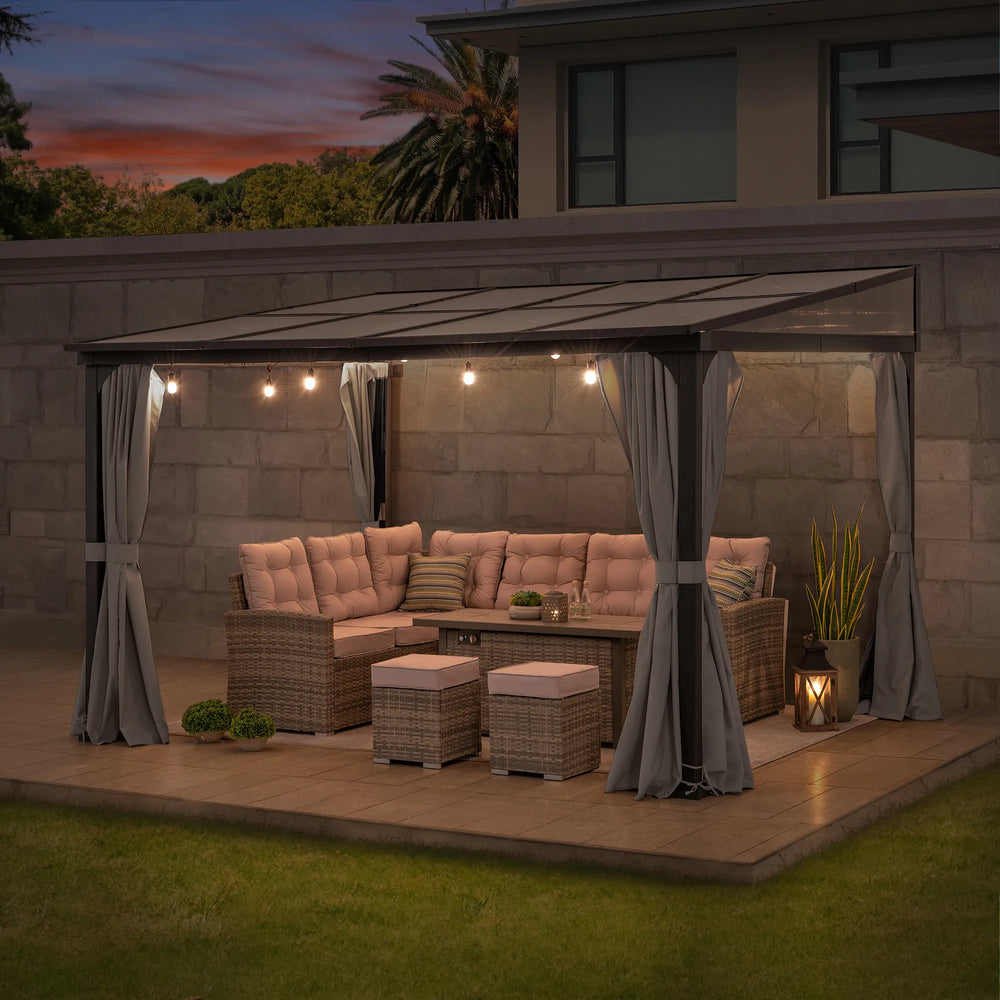 Outdoor patio setup with furniture and lighting under a pergola at dusk.