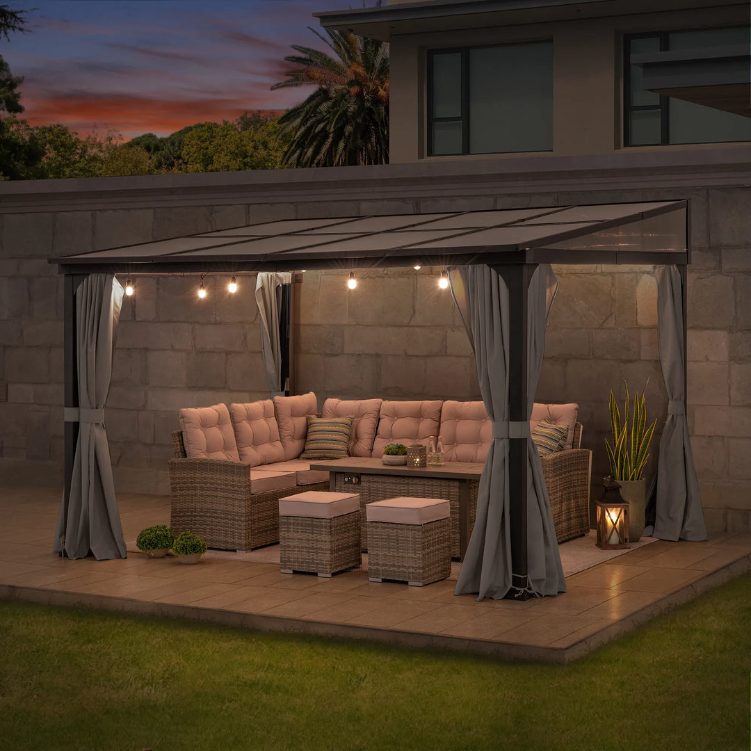 Outdoor patio setup with furniture and lighting under a pergola at dusk.