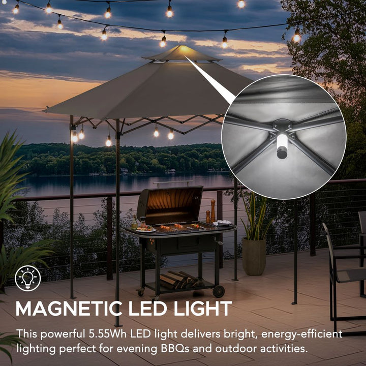Outdoor setting with a grill under a large umbrella, magnetic LED light highlighted, and scenic background.