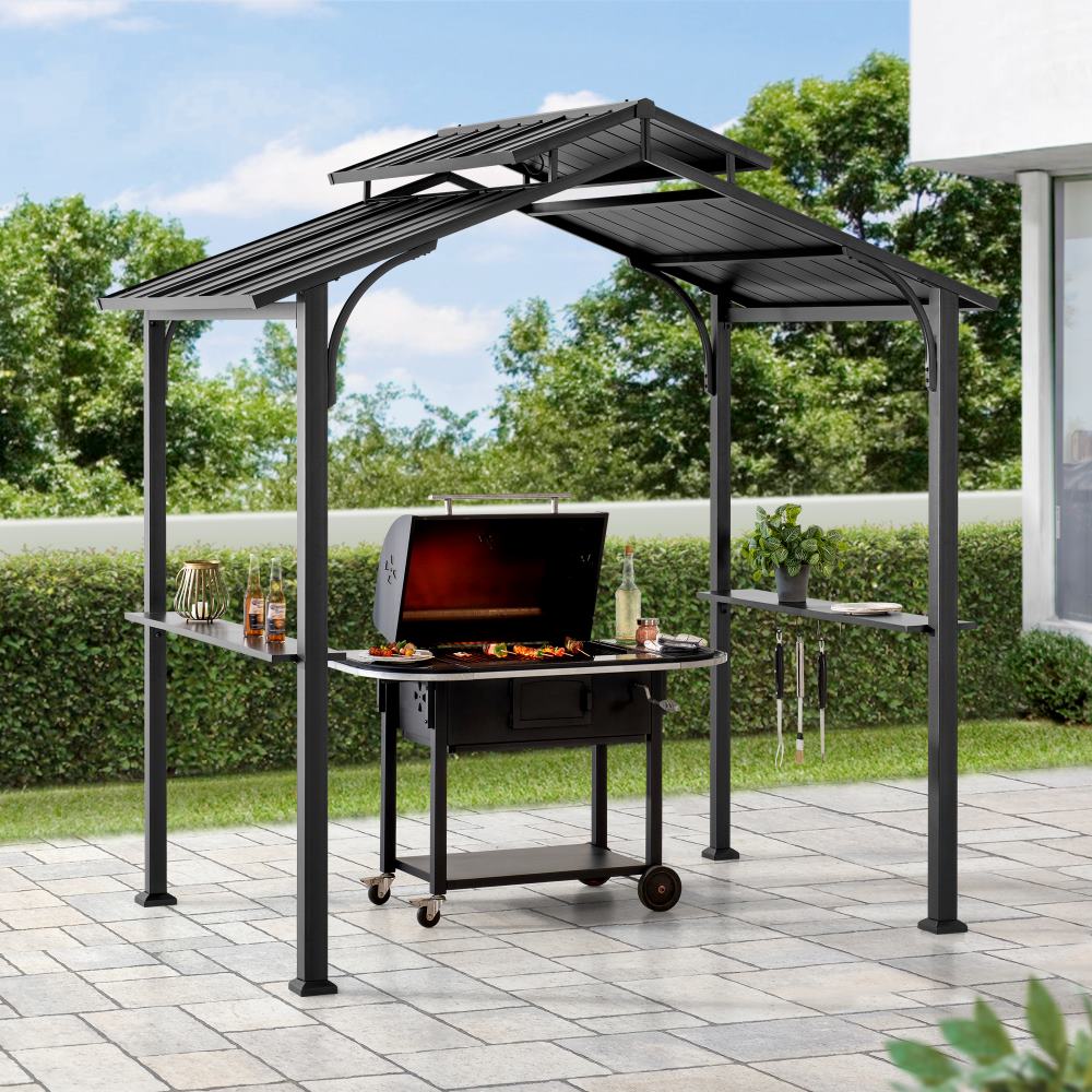 Outdoor grill with canopy on a patio area with greenery in the background