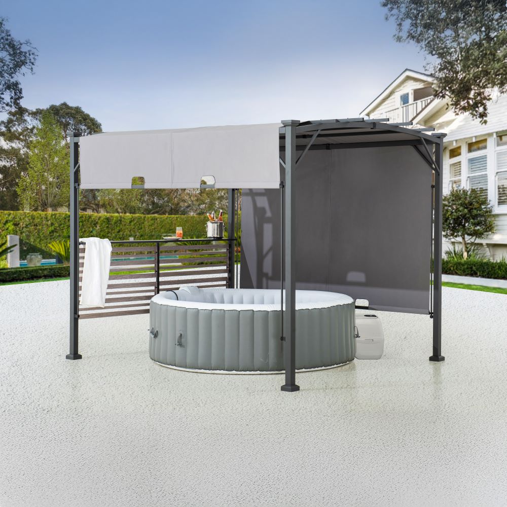 Portable hot tub under a gazebo with a house and garden in the background