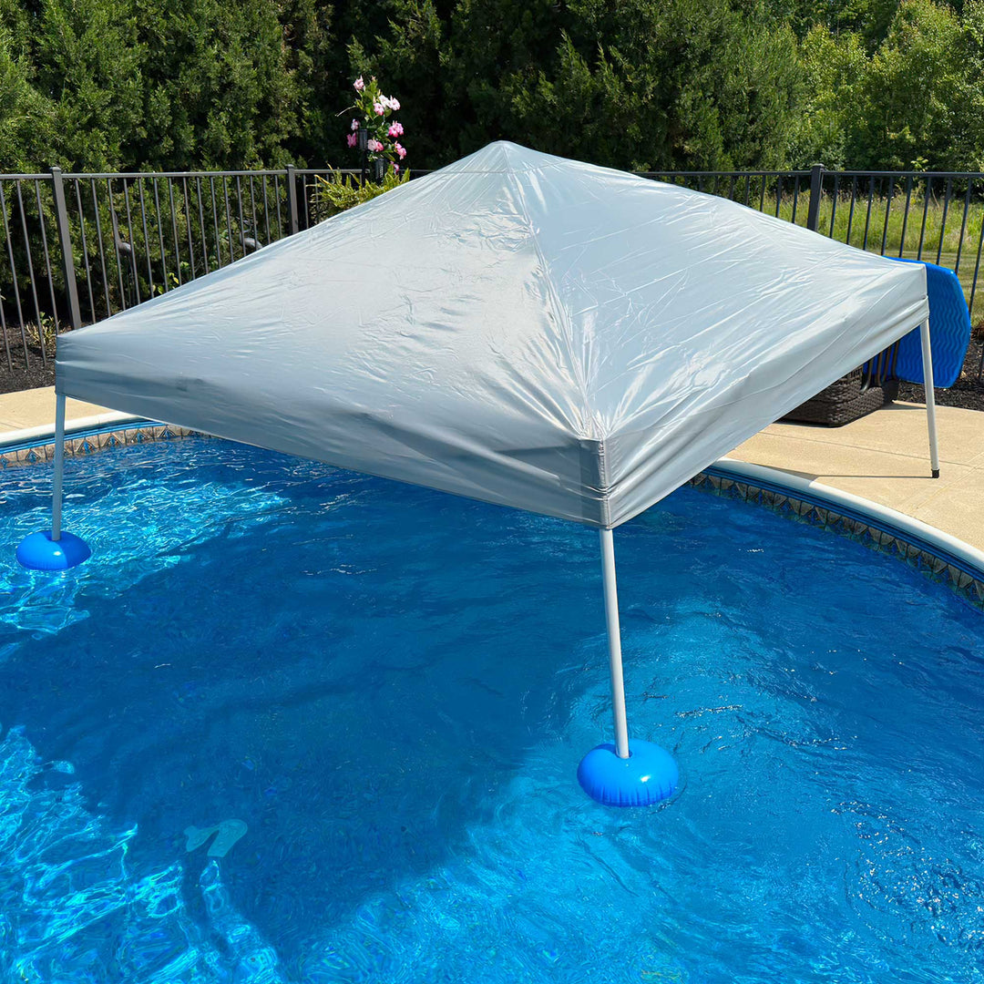 Portable canopy set up over a pool with blue floats on a sunny day.