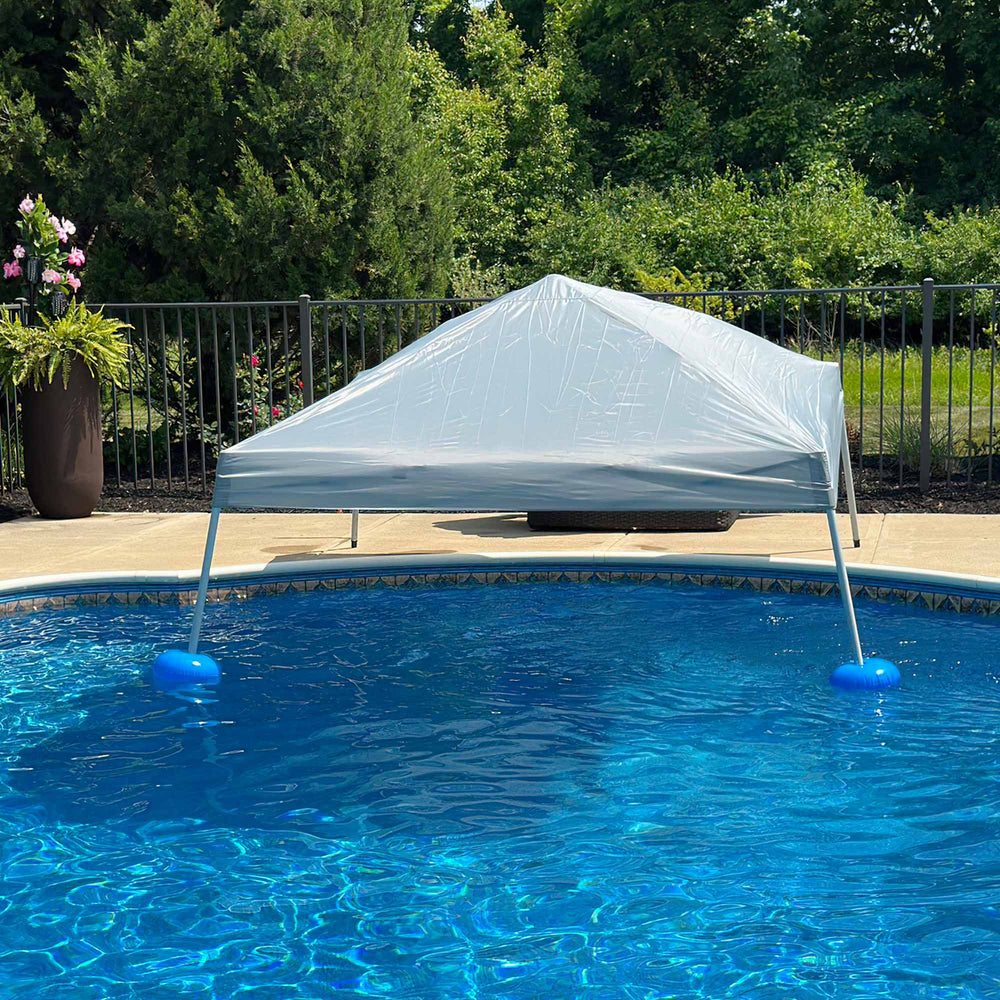 White pool cover on a pool with trees and a fence in the background