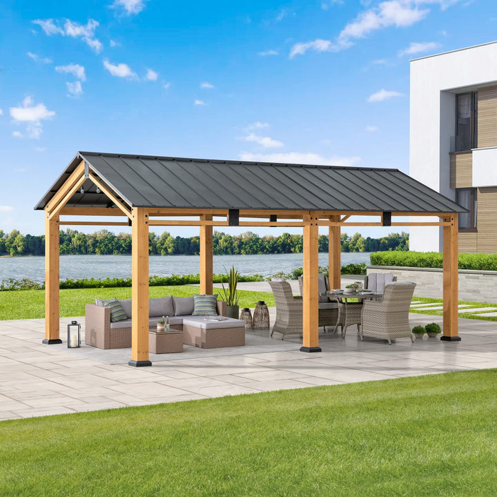 Outdoor patio with wooden pergola, furniture, and view of water and building.