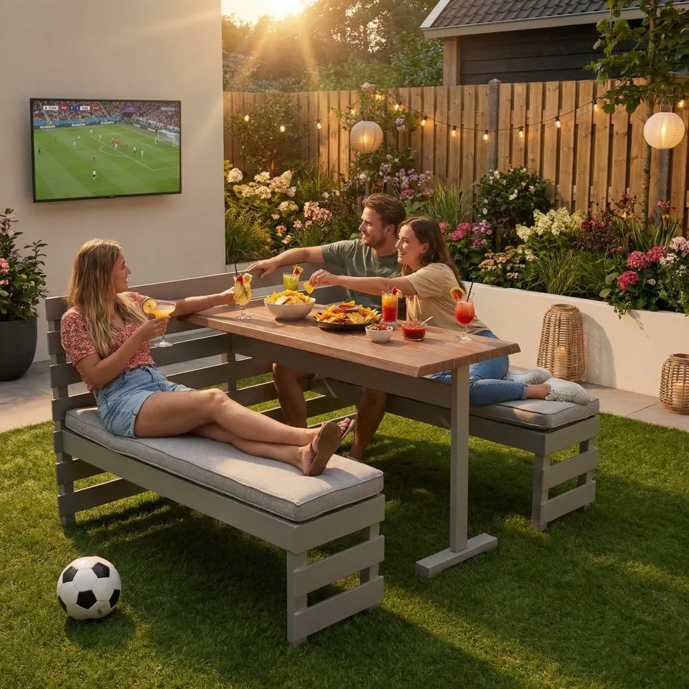 People enjoying a meal outdoors with a TV displaying a sports game in the background.