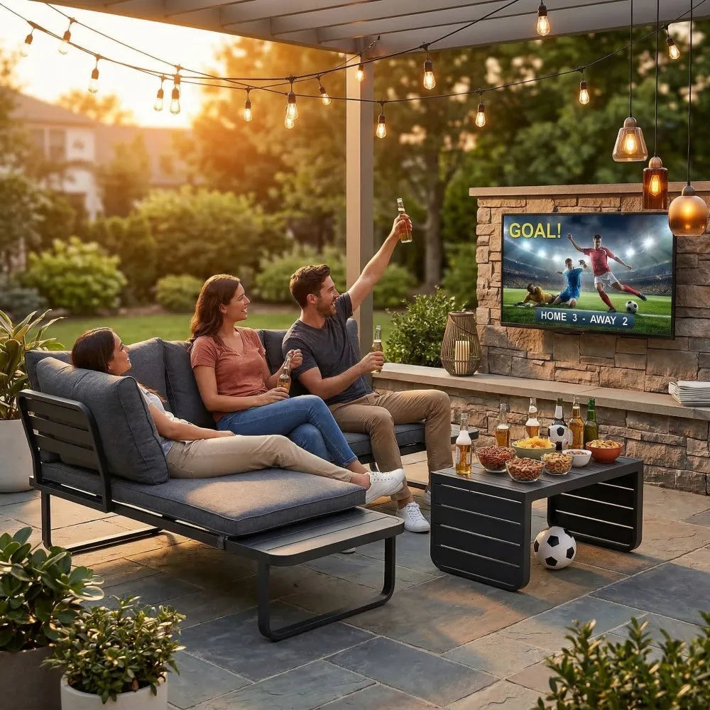 People watching a soccer match on a TV outdoors with patio furniture and drinks.
