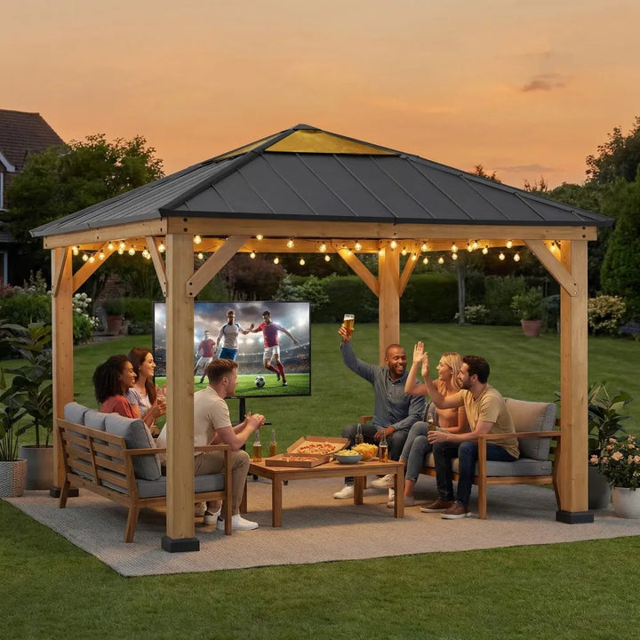 People watching a sports game on a screen in an outdoor gazebo with string lights.