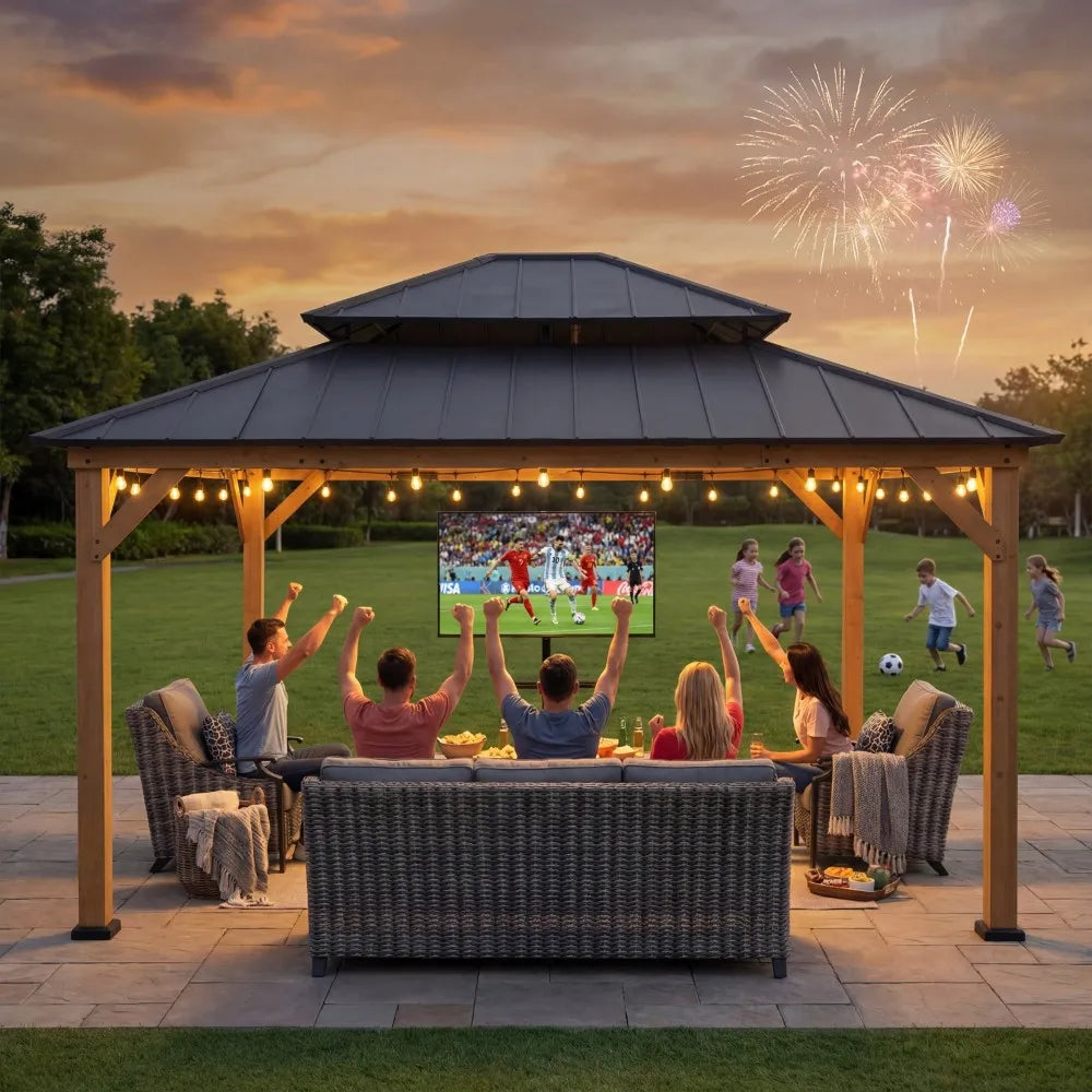 People watching a sports game on a screen in an outdoor gazebo with fireworks in the background