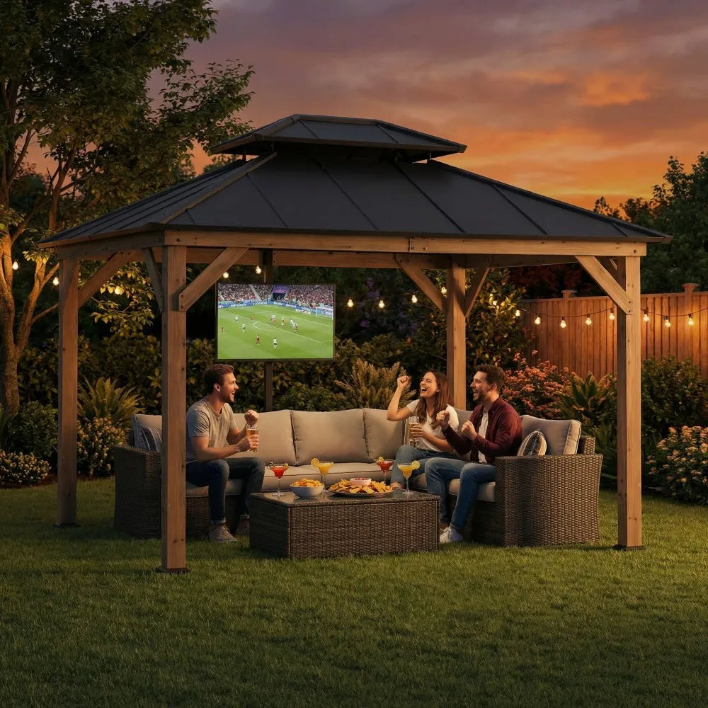 People sitting under a wooden gazebo watching TV in a garden setting with a sunset sky.