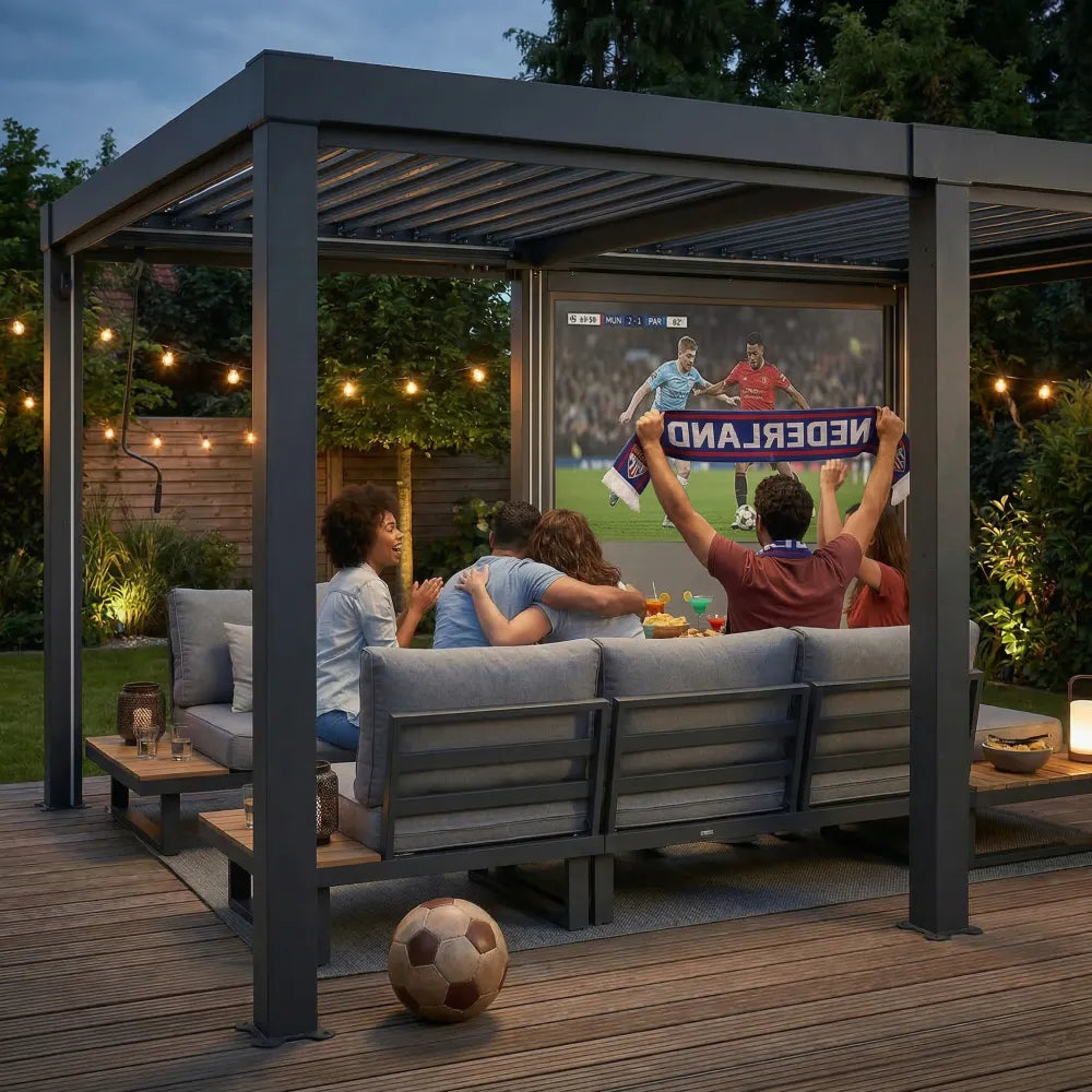 People watching a soccer match on an outdoor screen in a backyard with string lights.