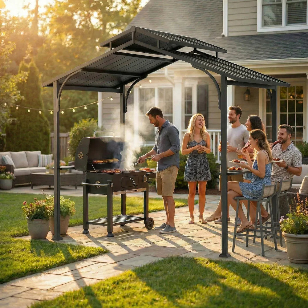 People gathered around a grill under a patio cover in a backyard setting.